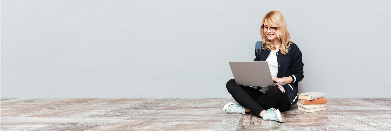 Blonde girl sitting on floor with laptop