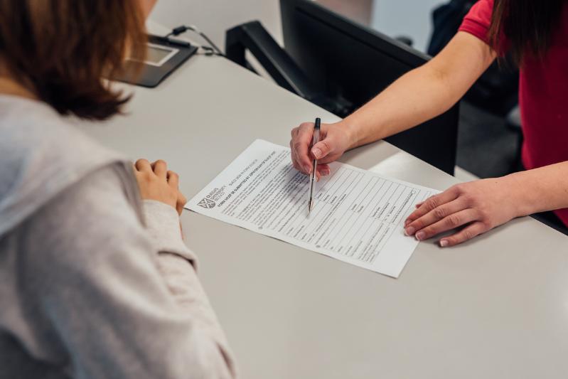 A student receiving support with filling in a form.