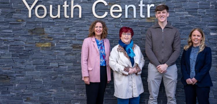 Image shows two academics, a local resident and a community worker pictured at an event.