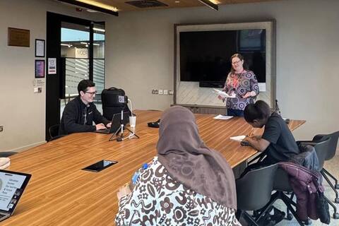 Education Society members sit at table for meeting