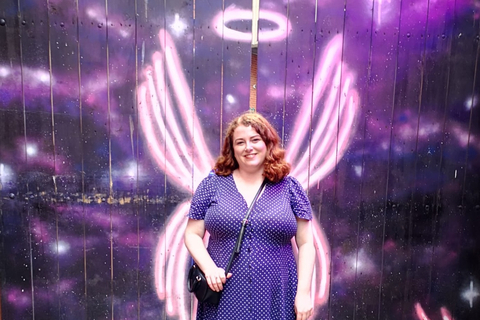 Hannah standing in front of angel graffiti beside Angel and Two Bibles in Belfast