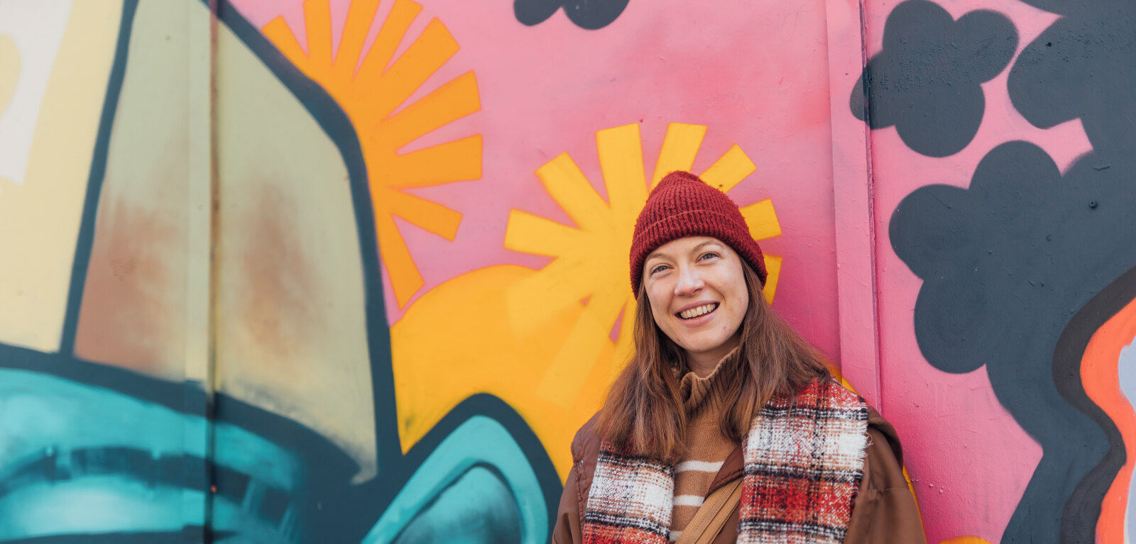 Student Lana stands against graffiti wall in Belfast