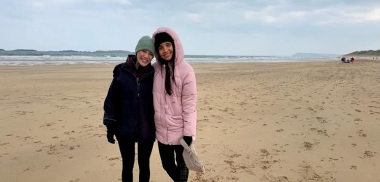 Two women standing on beach in Portrush