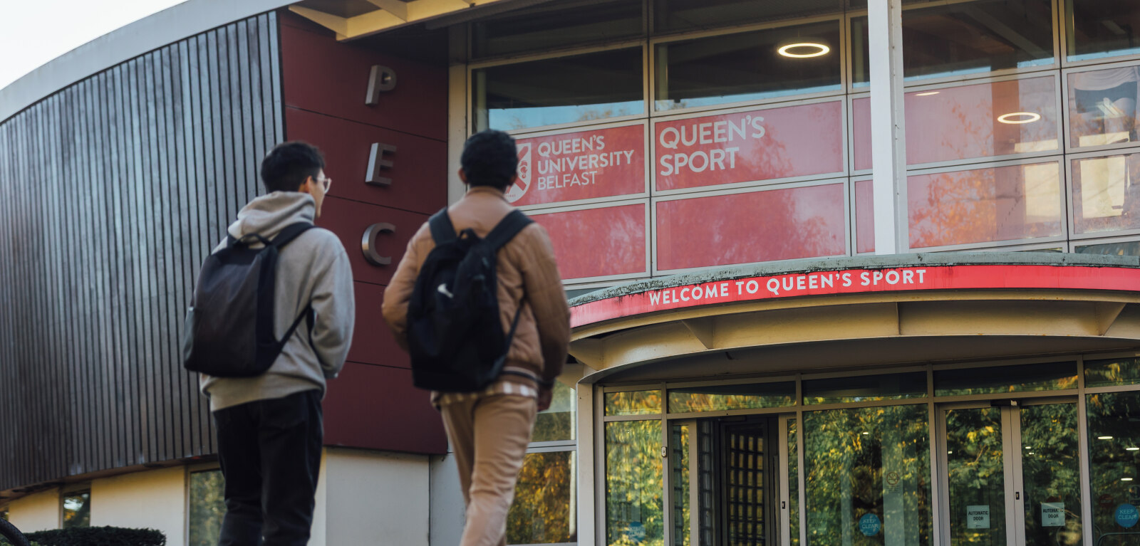 Two students walk towards PEC entrance