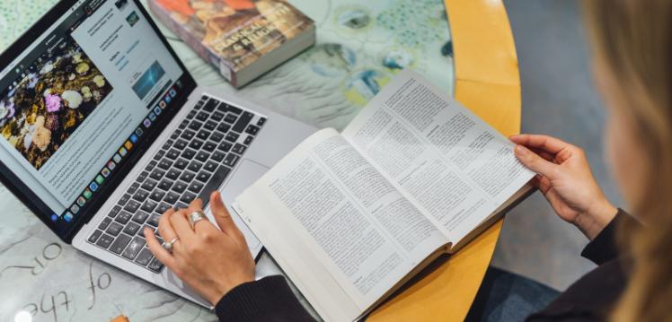 Student studying with laptop and books in CS Lewis Reading room