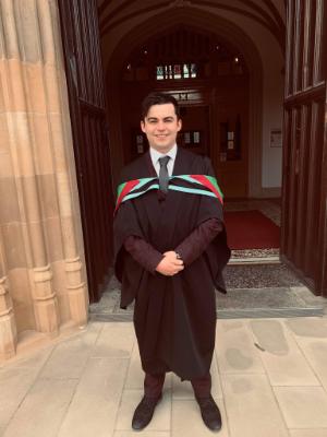 PhD student profile photo. A male student in his graduaton gown
