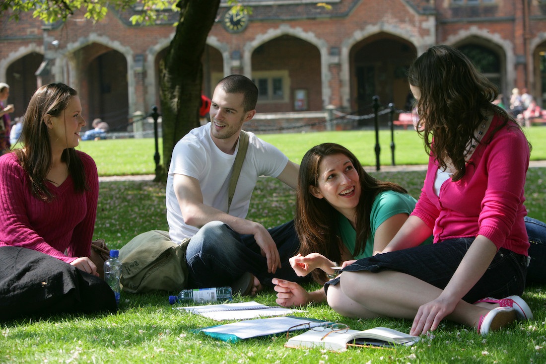 Students sitting in a sunny Quad in Queen's University Belfast