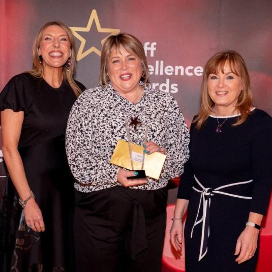 Maria Carrick (centre) holds her award at the Staff Excellence Awards 2021-22 celebration event