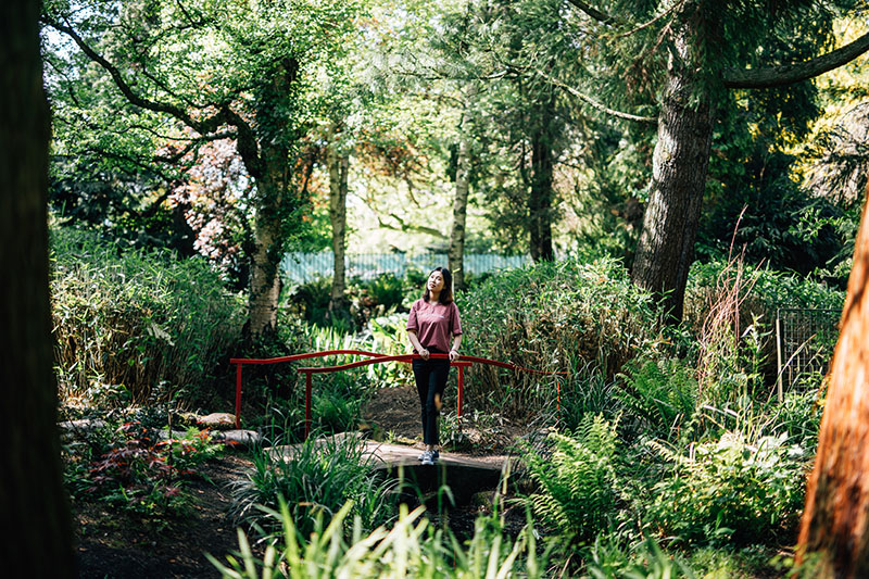 Student thinking on bridge in Botanic Gardens